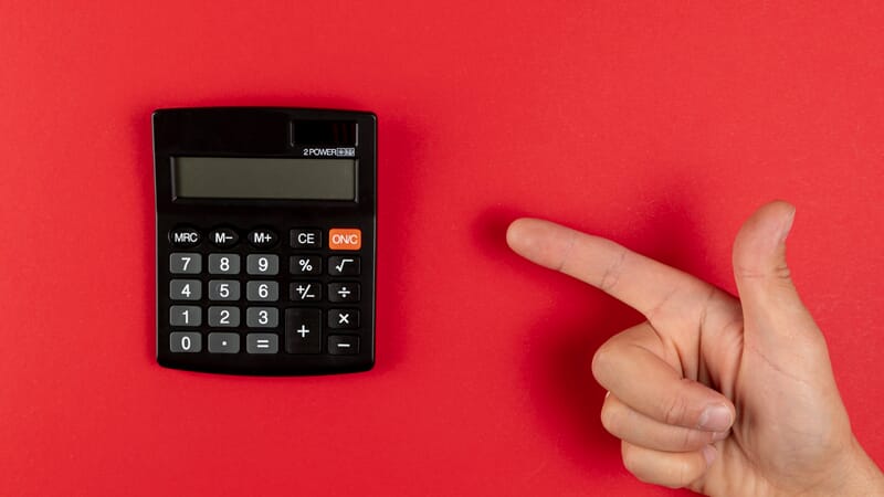 Hand pointing at a mini calculator