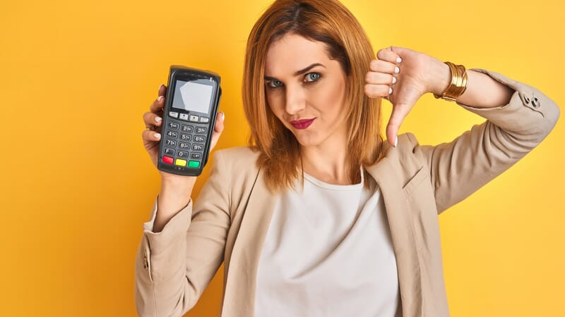 Business woman holding point of sale terminal with thumb down