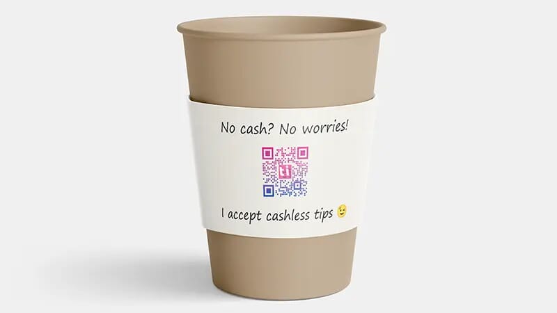 A coffee cup doubling as a tip jar. The sleeve shows that this is a tip jar, says that the person can accept cashless tips, and importantly also shows a QR code. When the customer scans the QR code they are taken to an electronic payment form so that they can securely pay a tip using their credit card.